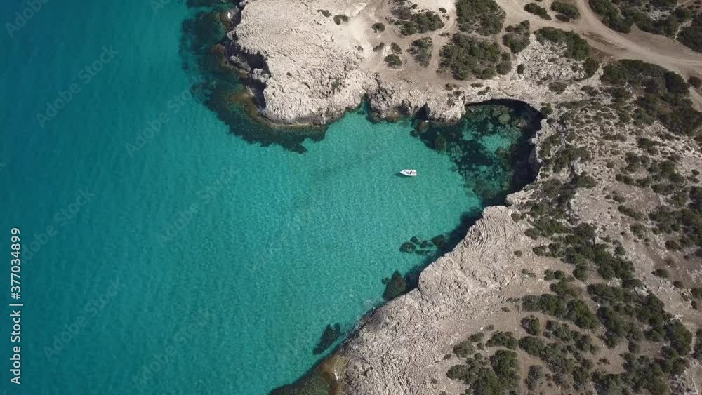 Boat Floating Under The Sun On The Crystal Clear Water Of Blue Lagoon Beach Near Paphos, Akamas Cyprus Island. - Aerial Drone Shot Boat Floating Under The Sun On The Crystal Clear Water Of Blue Lagoon Beach Near Paphos, Akamas Cyprus Island. - Aerial Drone Shot