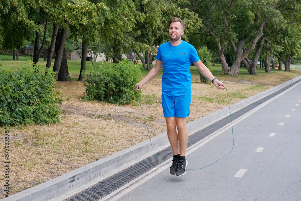 An athlete jumps on a rope before running. The man warms up before training. An athlete jumps on a rope before running. The man warms up before training.