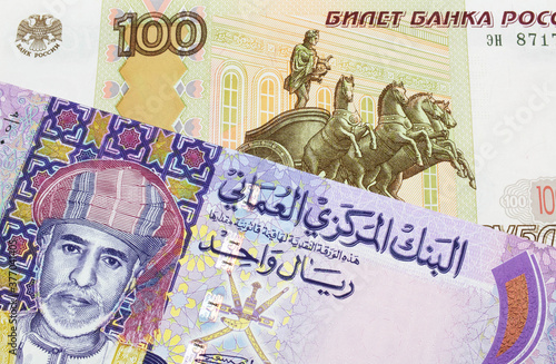 Wallpaper Mural A macro image of a Russian one hundred ruble note paired up with a colorful one rial note note from Oman.  Shot close up in macro. Torontodigital.ca