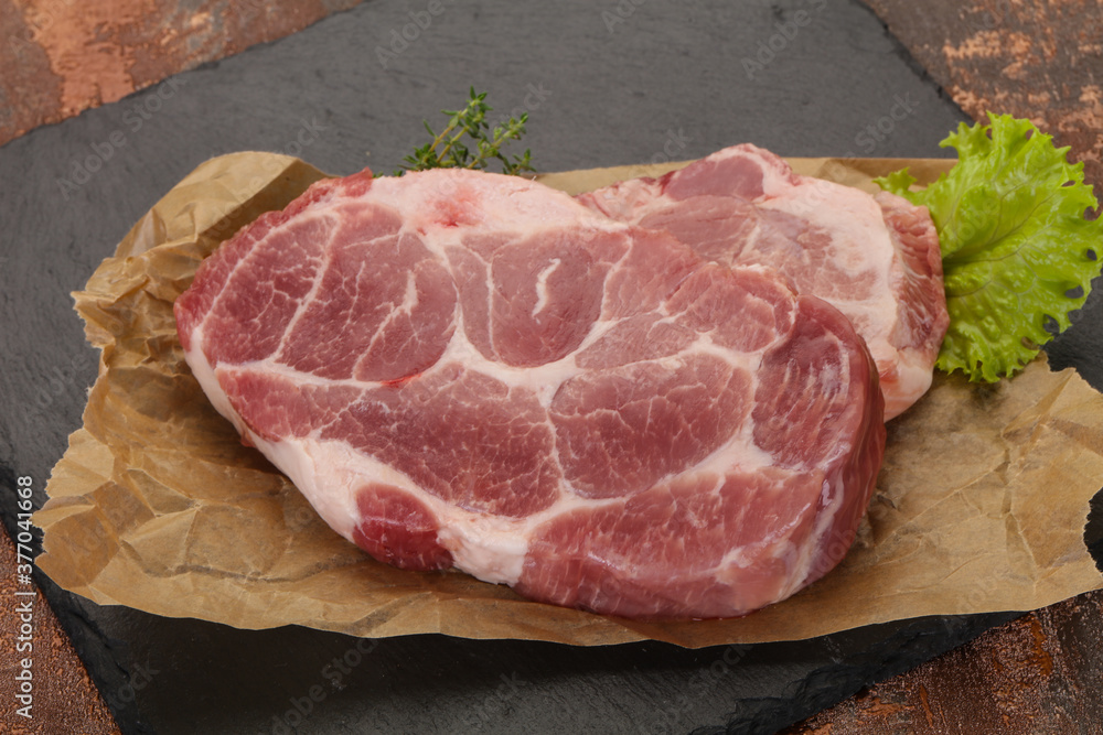 Raw pork steak over wooden board Raw pork steak over wooden board