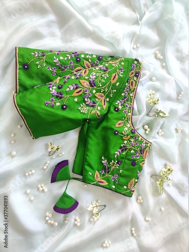 Beautiful green designer blouse with colourful flower embroidery by Indian designer © Praveen