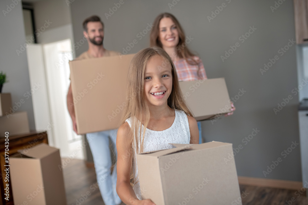 Family moving into new house and carrying cardoards Family moving into new house and carrying cardoards