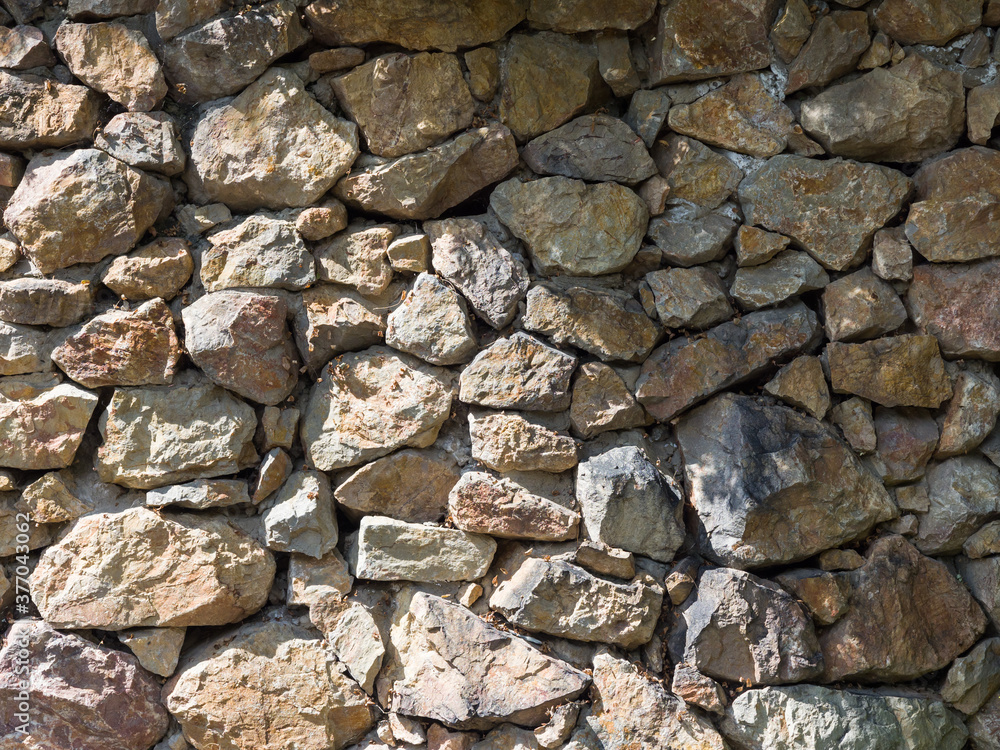 A wall of rough stones. Natural texture. Yellow-brown stones