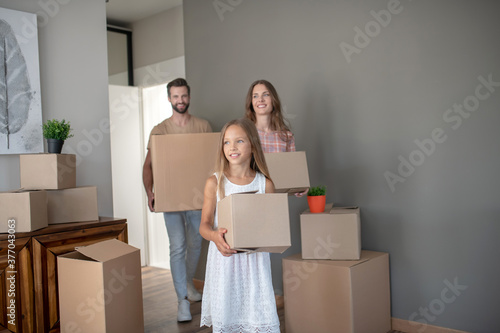 Young family moving into new house with cardboards © zinkevych