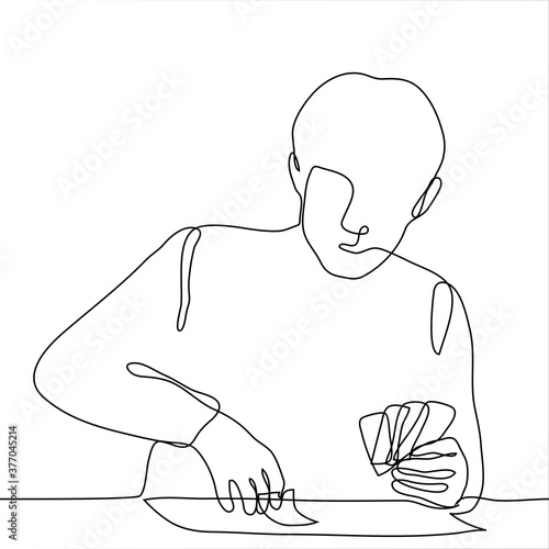 man sits at a table in his left hand he has cards, with his right hand he holds one lying on the table. one continuous line drawing of a man playing solitaire / playing card games / guessing on cards.