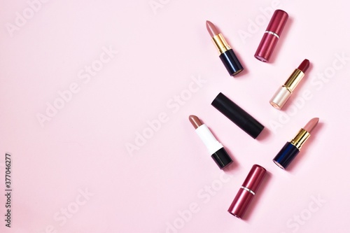 Several lipsticks on a pink background.Decorative cosmetics, make-up. space for text. top view.