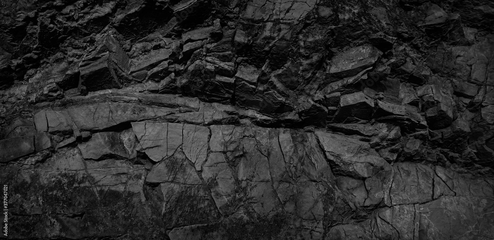 Black and white background. Volumetric black stone background. 3d effect. Rock texture. Granite mountain texture. Close-up.