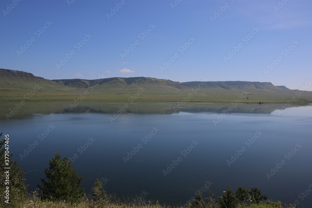 smooth lake with mountains and blue sky in summer