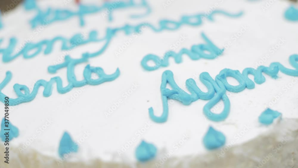 A celebration cake with white frosting, blue candy and three candles was prepared for a honeymoon celebration. A celebration cake with white frosting, blue candy and three candles was prepared for a honeymoon celebration.