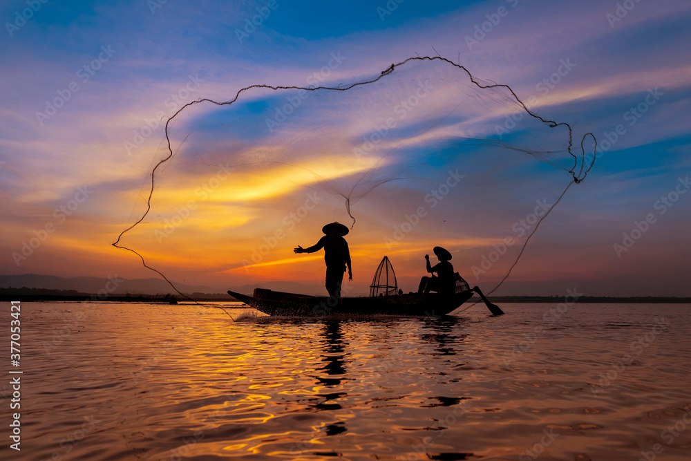 Asian fisherman with his wooden boat in nature river at the early morning before sunrise