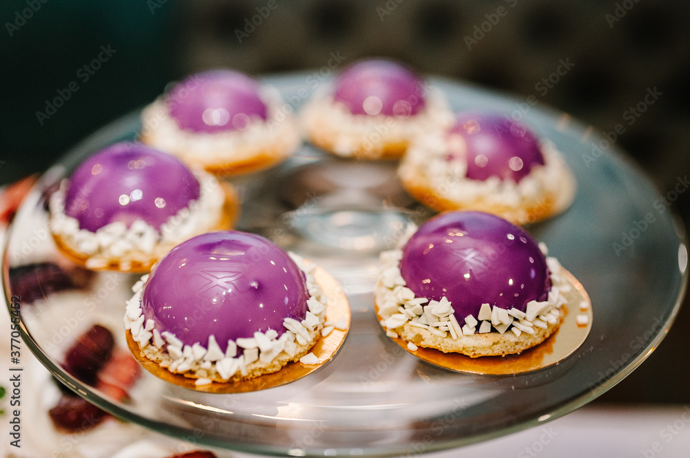 Delicious sweet vanilla cakes with purple colors. Festive sweet table with baking.