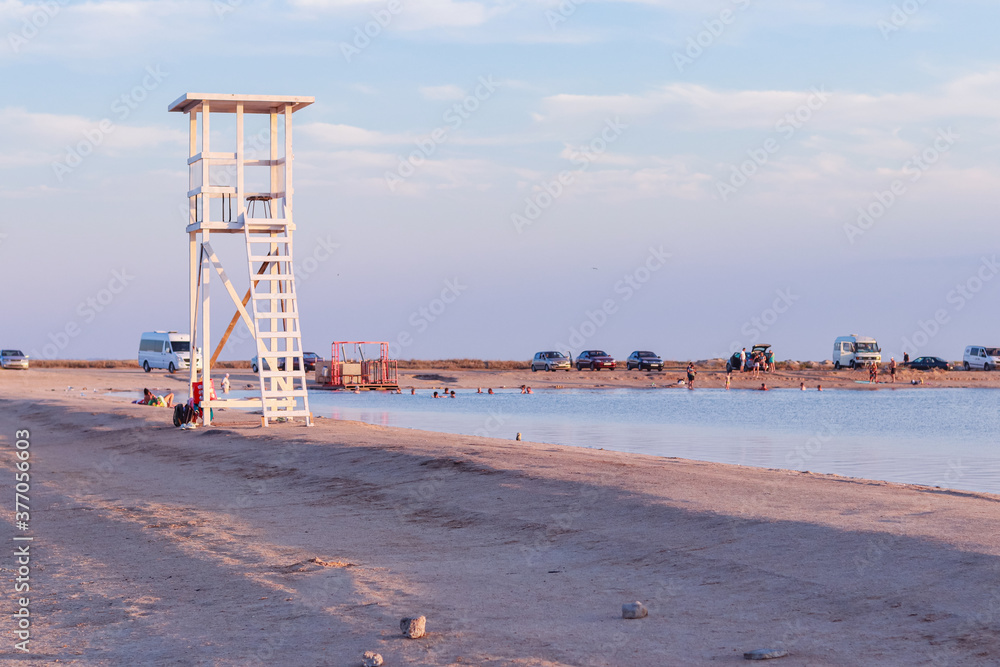 White wooden rescue tower on the shore of a salt lake