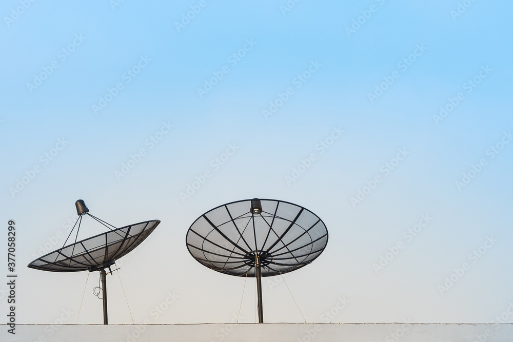Satellite dish antenna on top of the high rise building with clear sky.