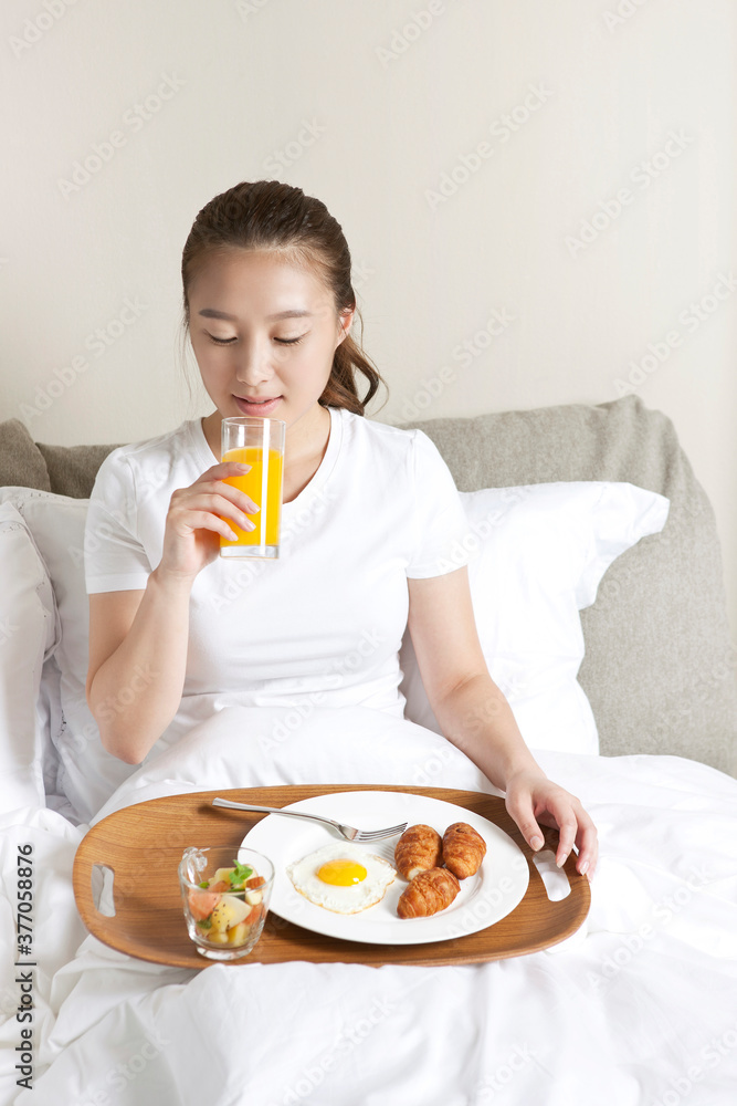 young woman having breakfast on bed young woman having breakfast on bed