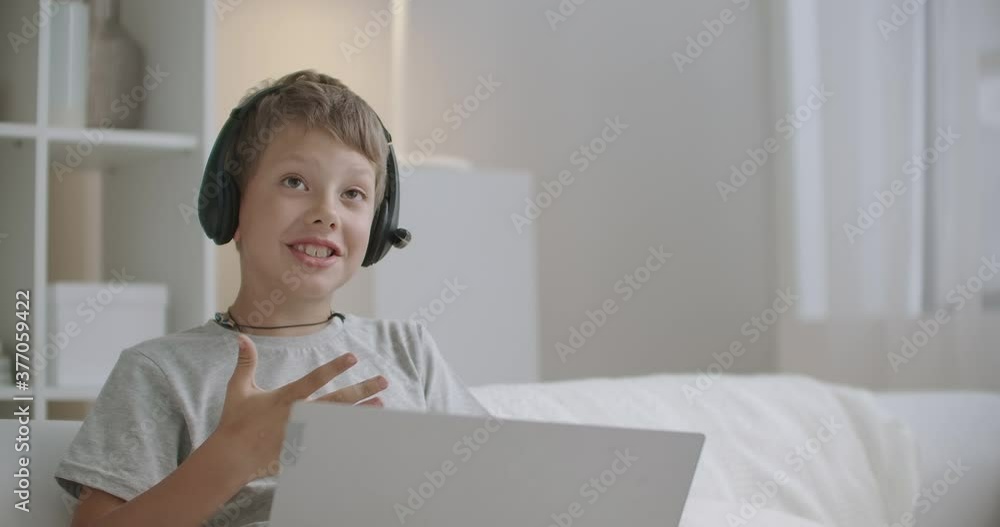naughty little boy is chatting online by laptop, active and positive child, sitting at home at weekends, portrait naughty little boy is chatting online by laptop, active and positive child, sitting at home at weekends, portrait