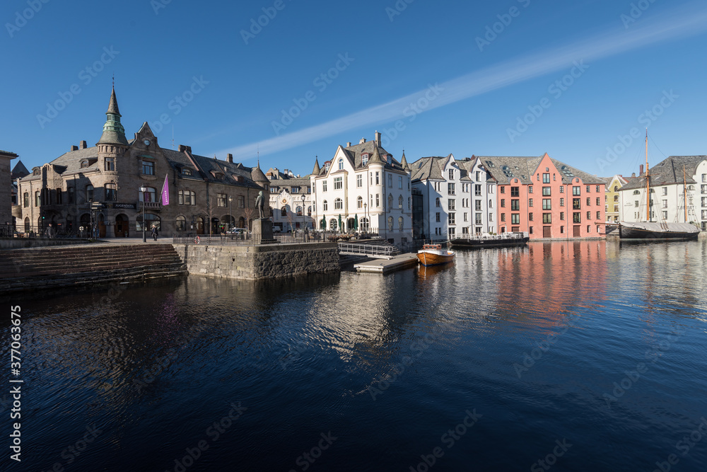 Beautiful old stone houses with art nouveau facades directly on the waterfront on the Apotekergata in Ålesund on a clear sunny winter day
