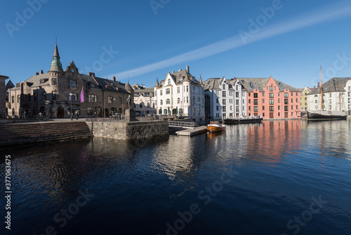 Beautiful old stone houses with art nouveau facades directly on the waterfront on the Apotekergata in Ålesund on a clear sunny winter day