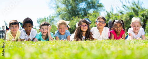 Portrait of children who are posing lying in the park. High quality photo © JackF