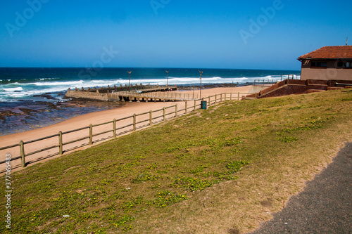 Wood Fence Between Grass Walkway and Beach with Tidal Pool