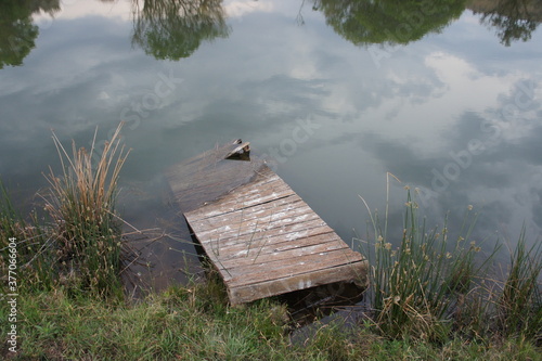Broken jetty on the edge of a lake.