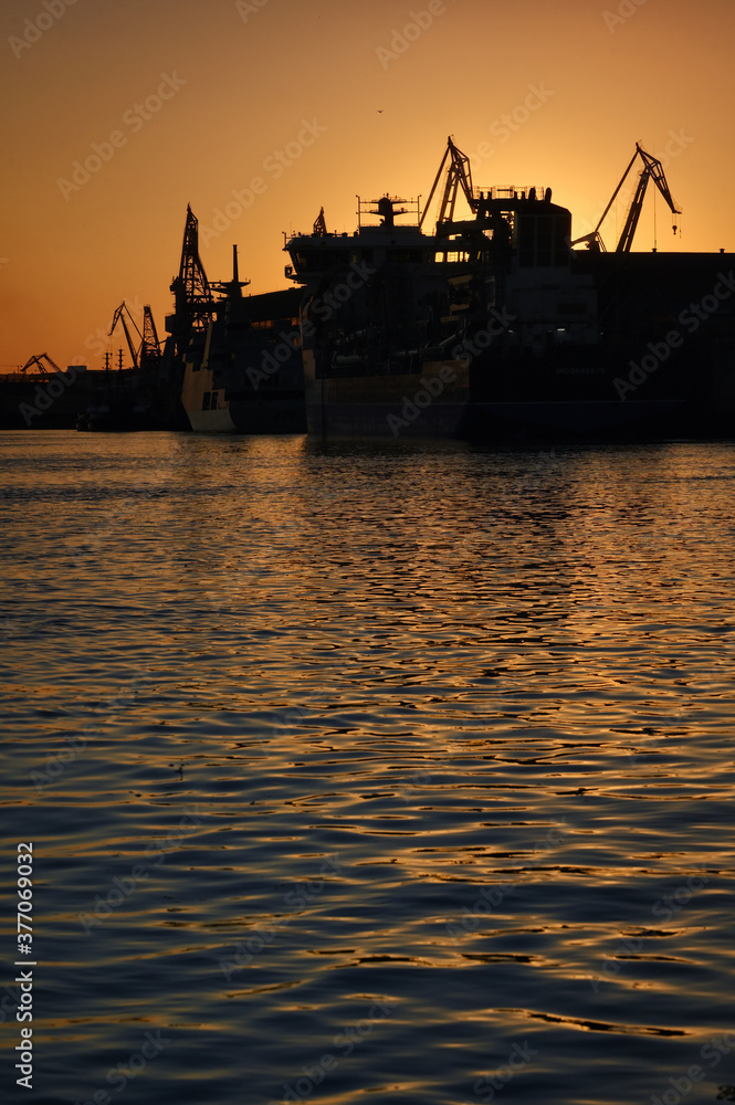 Harbor and Cranes against red sunset background