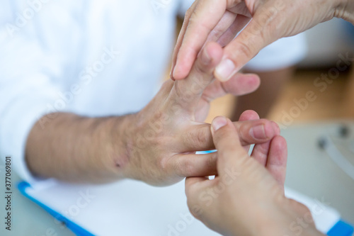 Healthcare - orthopedist examining patients hand.