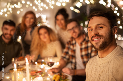holidays  celebration and people concept - happy friends taking selfie at home christmas dinner party