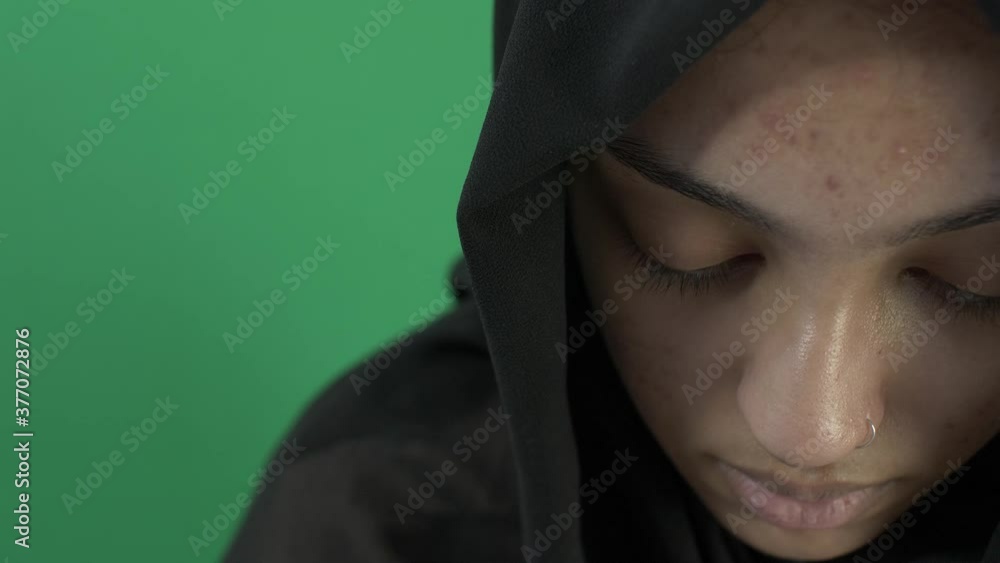 Young Asian Muslim Looking Downcast. Close Up, Green Screen, Locked Off Young Asian Muslim Looking Downcast. Close Up, Green Screen, Locked Off