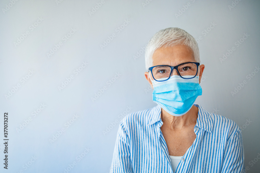 Closeup up portrait of adult woman wearing medical mask indoors. Looking at camera. Virus concept. Portrait of woman wearing face mask during Covid-19 pandemic outbreak