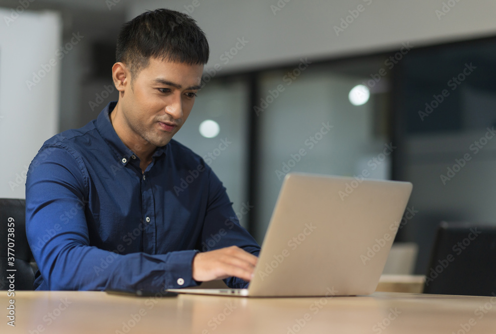 Young asian businessman working with laptop in office. Young asian businessman working with laptop in office.