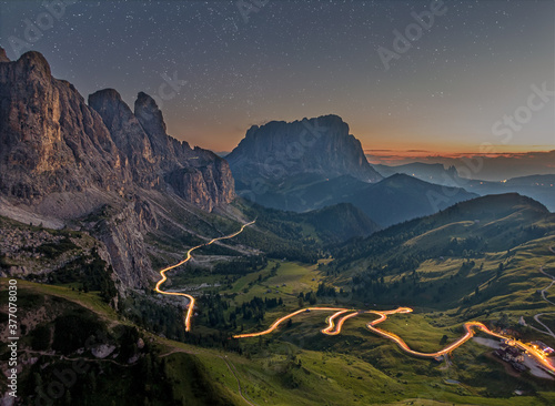 Nighttime image of the Gardena pass with stars, milky way and lighttrails in South Tyrol, the Italian Dolomites