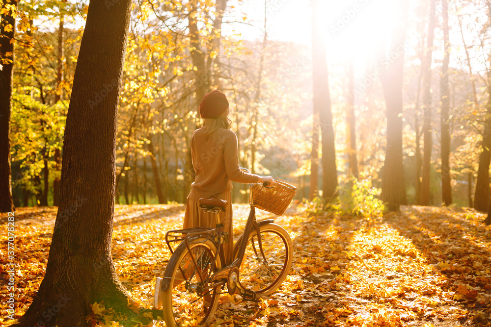 Autumn woman in autumn park. Happy young woman posing with bike in autumn forest. - obrazy, fototapety, plakaty 