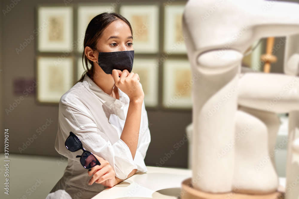 Woman visitor in the historical museum looking at art object Woman visitor in the historical museum looking at art object
