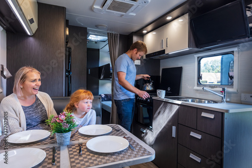 A young man preparing a cup of tea for his family in a modern Australian Caravan