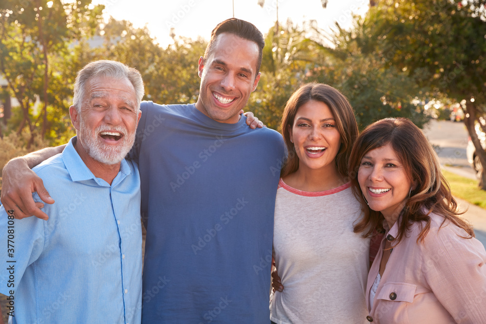 Portrait Of Senior Hispanic Parents With Adult Son And Daughter Relaxing In Garden At Home Together Portrait Of Senior Hispanic Parents With Adult Son And Daughter Relaxing In Garden At Home Together