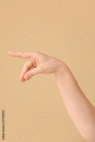 Hand showing letter Q on color background. Sign language alphabet