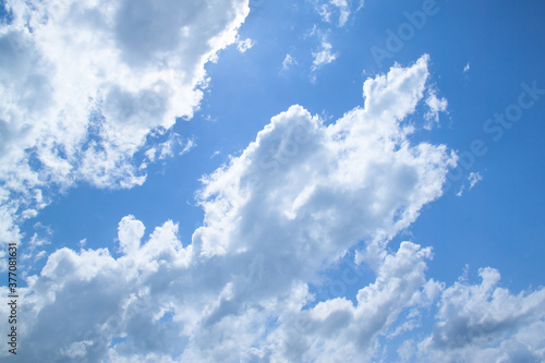 White fluffy clouds in a bright blue sky on a sunny day.