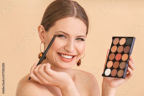 Billede på lærred Young woman with beautiful eyeshadows on color background