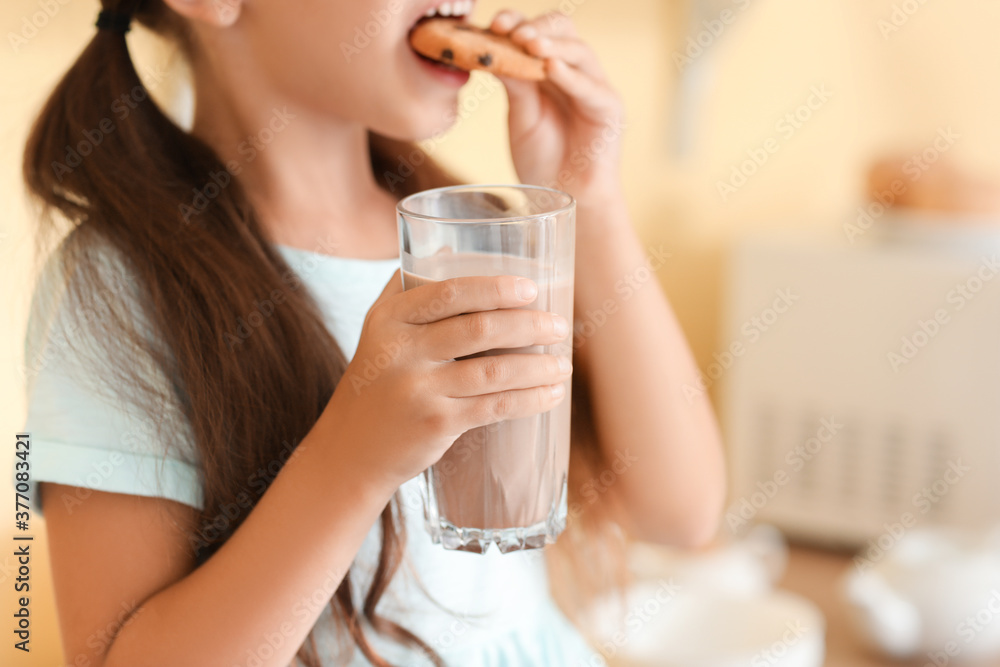 Little girl drinking tasty chocolate milk and eating cookies at home Little girl drinking tasty chocolate milk and eating cookies at home