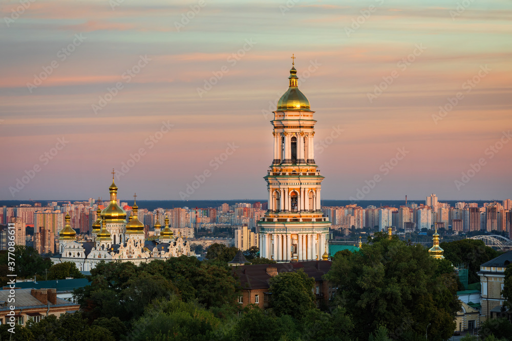 View to the Bell Tower of Kyiv Pechersk Lavra  and cityscape behind of it at sunset.