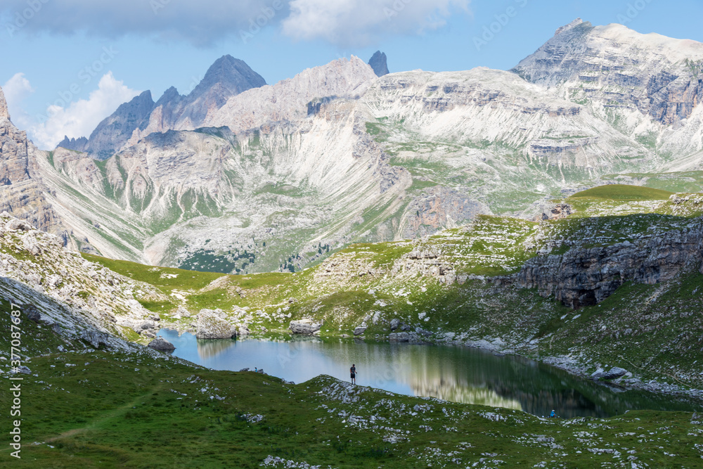 Panoramic view over Crespeina Lake, a pristine Alpine lake located at an altitude of 2300m (7500ft) in the Puez-Odle mountain range in a cloudy summer day. South Tyrol, Italy