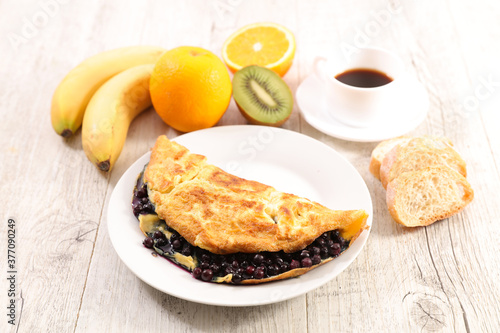 omelette with blueberries, fruit and coffee cup