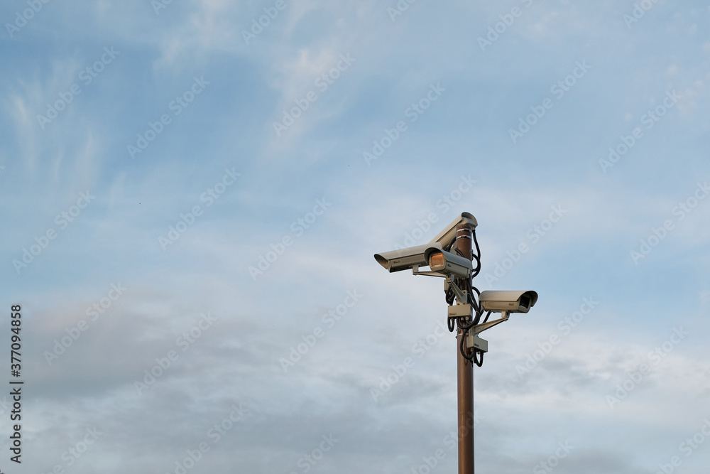 Security cameras on the pillar. cloudy evening sky on background.