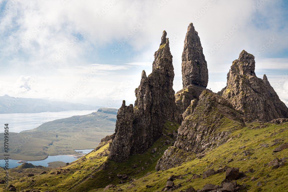 The Old Man of Storr - famous rocky formation in Trotternish landslip, Isle of Skye, Scotland. Scenic view of the iconic rocky pinnacles and surrounding landscape on a sunny day