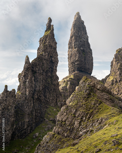The Old Man of Storr - famous rocky formation in Trotternish landslip, Isle of Skye, Scotland. Scenic view of the iconic rocky pinnacles, silhouettes of people next to the Old Man © hopsalka