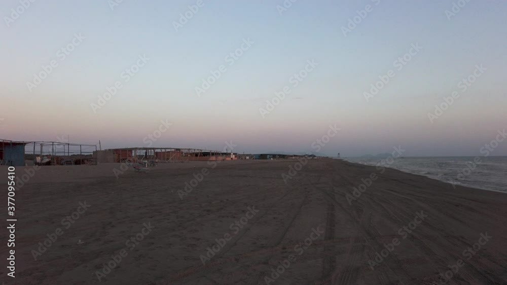 moving on a beach in Albania at the end of the day. visible tyre tracks on the sand moving on a beach in Albania at the end of the day. visible tyre tracks on the sand