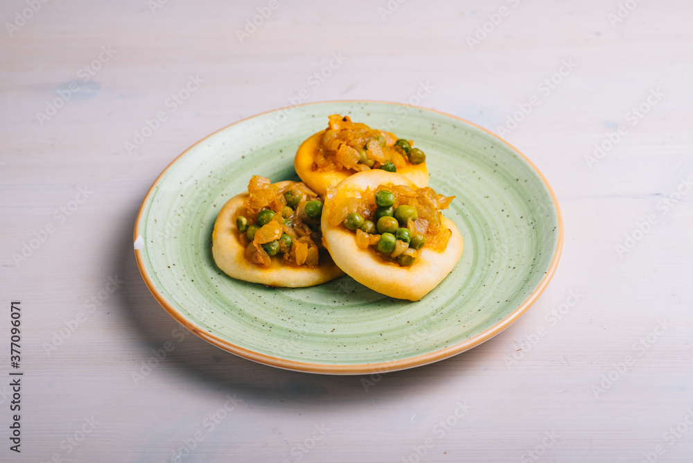 Freshly baked mini pizza сoca with with peas and carrots and onions. Traditional Spanish pastry with vegetables. Freshly baked mini pizza сoca with with peas and carrots and onions. Traditional Spanish pastry with vegetables.