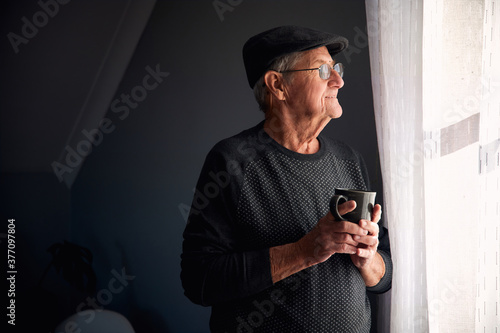 Senior man smiling out of window