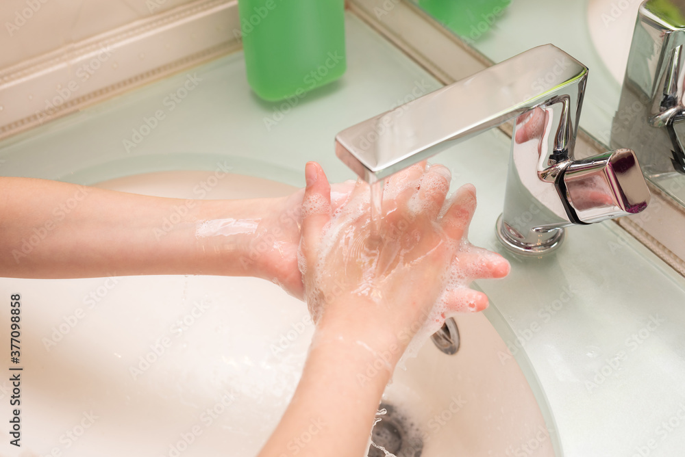 Fototapeta premium Hygiene concept. Washing hands with soap under the faucet with water