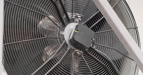 Close up shot of a spinning ventilator conditional an industrial space in bug sized in slow motion, cleaning airflow, cooling down the temperature, refrigeration indoor. Providing comfort climate zone